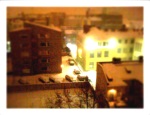 The view of my back area at night on a snowy evening. The image has the tilt-shift effect applied.