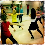 A group of girls practicing for a holiday salsa party practice bachata.